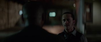 Movie still from “Triple 9” (2016), directed by John Hillcoat – A man in a suit and tie talking to another man in a suit and tie; Close Up shot, Over the shoulder angle