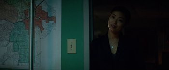 Movie still from “Triple 9” (2016), directed by John Hillcoat – A woman standing next to a light switch in a dark room; Close Up shot, Over the shoulder angle