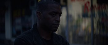 Movie still from “Triple 9” (2016), directed by John Hillcoat – A person wearing a black shirt; Close Up shot, Low angle