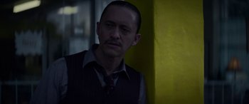 Movie still from “Triple 9” (2016), directed by John Hillcoat – A person wearing a suit and tie; Close Up shot, Low angle