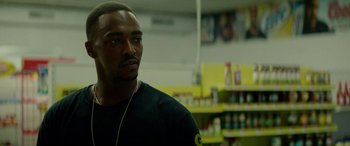 Movie still from “Triple 9” (2016), directed by John Hillcoat – A man with headphones looking at something in the distance; Close Up shot, Over the shoulder angle