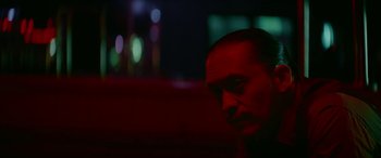 Movie still from “Triple 9” (2016), directed by John Hillcoat – A person's face in a dark room; Close Up shot, Low angle
