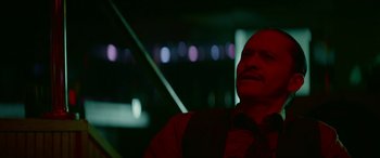 Movie still from “Triple 9” (2016), directed by John Hillcoat – A man in a red shirt and a black tie; Close Up shot, Low angle