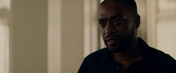 Movie still from “Triple 9” (2016), directed by John Hillcoat – A person wearing a black shirt; Close Up shot, Over the shoulder angle