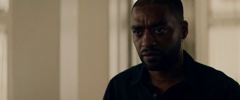 Movie still from “Triple 9” (2016), directed by John Hillcoat – A person wearing a black shirt; Close Up shot, Over the shoulder angle