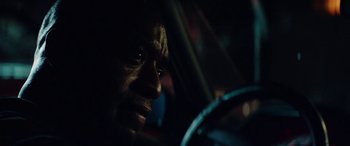Movie still from “Triple 9” (2016), directed by John Hillcoat – A man's face as he drives a car at night; Close Up shot, Over the shoulder angle