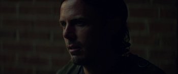 Movie still from “Triple 9” (2016), directed by John Hillcoat – A person's face in the dark; Close Up shot, Over the shoulder angle