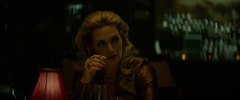 Movie still from “Triple 9” (2016), directed by John Hillcoat – A woman sitting in front of a glass of wine; Close Up shot, Over the shoulder angle