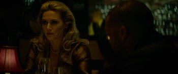 Movie still from “Triple 9” (2016), directed by John Hillcoat – A woman sitting at a table with a glass of wine in front of a man; Close Up shot, Over the shoulder angle