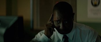 Movie still from “Triple 9” (2016), directed by John Hillcoat – A person wearing a shirt and tie; Close Up shot, Low angle