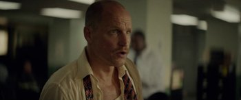 Movie still from “Triple 9” (2016), directed by John Hillcoat – A bald man with a mustache wearing a neck tie; Close Up shot, Low angle
