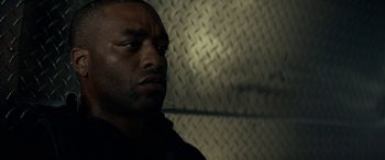 Movie still from “Triple 9” (2016), directed by John Hillcoat – A person looking at the camera; Close Up shot, Low angle