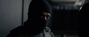Movie still from “Triple 9” (2016), directed by John Hillcoat – A man wearing a black balaclava is looking at the camera; Close Up shot, Over the shoulder angle