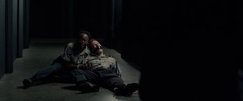 Movie still from “Triple 9” (2016), directed by John Hillcoat – Two men in uniforms are lying on the ground; Medium shot, High angle