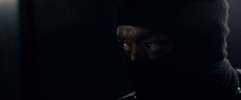Movie still from “Triple 9” (2016), directed by John Hillcoat – A man in a black mask looking at the camera; Extreme Close Up shot, Low angle