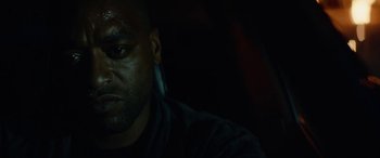 Movie still from “Triple 9” (2016), directed by John Hillcoat – A man's face in the dark; Close Up shot, Low angle
