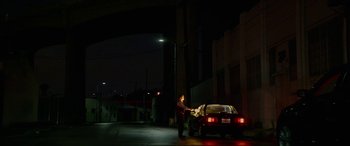 Movie still from “Triple 9” (2016), directed by John Hillcoat – A man standing next to a car on the side of the road; Extreme Wide shot, Low angle