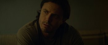 Movie still from “Triple 9” (2016), directed by John Hillcoat – A person with long dark hair; Close Up shot, Over the shoulder angle