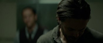 Movie still from “Triple 9” (2016), directed by John Hillcoat – A person with long dark hair; Close Up shot, Over the shoulder angle