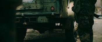 Movie still from “Triple Threat” (2019), directed by Jesse V. Johnson – The rear end of an old rusted truck; Wide shot, Low angle
