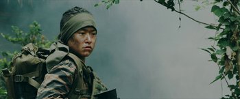 Movie still from “Triple Threat” (2019), directed by Jesse V. Johnson – A man in a military uniform is holding a book; Close Up shot, Low angle