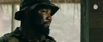 Movie still from “Triple Threat” (2019), directed by Jesse V. Johnson – A person wearing a hat; Close Up shot, Over the shoulder angle