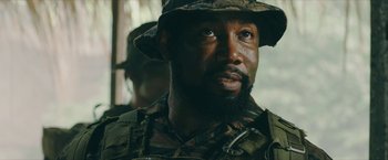 Movie still from “Triple Threat” (2019), directed by Jesse V. Johnson – A person wearing a hat; Close Up shot, Over the shoulder angle