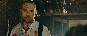 Movie still from “Triple Threat” (2019), directed by Jesse V. Johnson – A person wearing a shirt and tie; Close Up shot, Over the shoulder angle