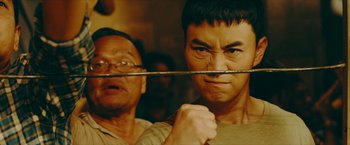 Movie still from “Triple Threat” (2019), directed by Jesse V. Johnson – A man holding a sword in front of another man's face; Close Up shot, Over the shoulder angle