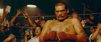 Movie still from “Triple Threat” (2019), directed by Jesse V. Johnson – A person in a boxing ring; Medium shot, Low angle