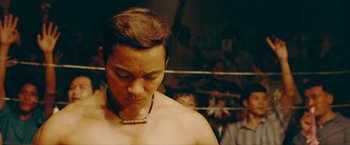 Movie still from “Triple Threat” (2019), directed by Jesse V. Johnson – A man with a necklace in a boxing ring; Close Up shot, Low angle