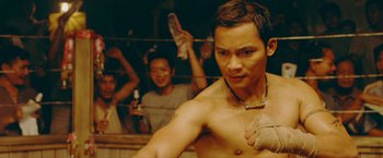 Movie still from “Triple Threat” (2019), directed by Jesse V. Johnson – A man in a boxing ring getting ready for a fight; Close Up shot, Low angle