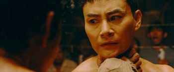 Movie still from “Triple Threat” (2019), directed by Jesse V. Johnson – A man's face in a boxing ring; Close Up shot, Over the shoulder angle