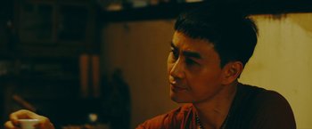 Movie still from “Triple Threat” (2019), directed by Jesse V. Johnson – A person wearing a red shirt; Close Up shot, Over the shoulder angle