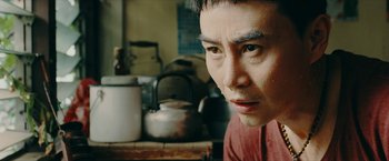 Movie still from “Triple Threat” (2019), directed by Jesse V. Johnson – A person in a room; Close Up shot, Over the shoulder angle