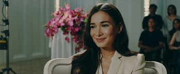 Movie still from “Triple Threat” (2019), directed by Jesse V. Johnson – A beautiful young woman sitting in a chair; Close Up shot, Over the shoulder angle