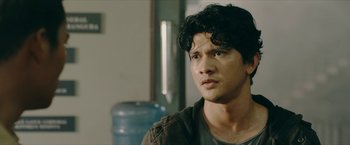 Movie still from “Triple Threat” (2019), directed by Jesse V. Johnson – A person wearing a brown jacket; Close Up shot, Over the shoulder angle