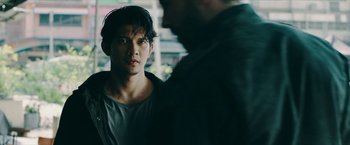 Movie still from “Triple Threat” (2019), directed by Jesse V. Johnson – A man standing next to another man in front of a building; Close Up shot, Over the shoulder angle