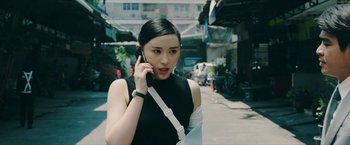 Movie still from “Triple Threat” (2019), directed by Jesse V. Johnson – A woman is talking on a cell phone while walking down the street; Close Up shot, Low angle
