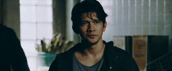 Movie still from “Triple Threat” (2019), directed by Jesse V. Johnson – A person wearing a black jacket; Close Up shot, Over the shoulder angle