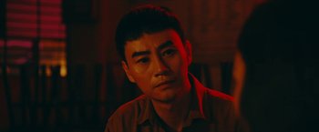 Movie still from “Triple Threat” (2019), directed by Jesse V. Johnson – A person wearing a brown shirt; Close Up shot, Over the shoulder angle