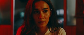 Movie still from “Triple Threat” (2019), directed by Jesse V. Johnson – A woman's face in the dark; Close Up shot, Over the shoulder angle