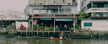 Movie still from “Triple Threat” (2019), directed by Jesse V. Johnson – A group of people in a boat on a body of water; Extreme Wide shot, High angle
