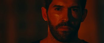 Movie still from “Triple Threat” (2019), directed by Jesse V. Johnson – A man with a beard; Close Up shot, Over the shoulder angle