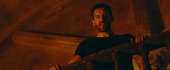 Movie still from “Triple Threat” (2019), directed by Jesse V. Johnson – A person holding a skateboard; Close Up shot, Low angle