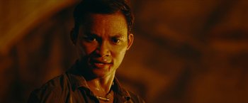 Movie still from “Triple Threat” (2019), directed by Jesse V. Johnson – A person wearing a brown shirt; Close Up shot, Low angle