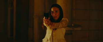 Movie still from “Triple Threat” (2019), directed by Jesse V. Johnson – A woman is holding a gun in her hand; Medium shot, Low angle