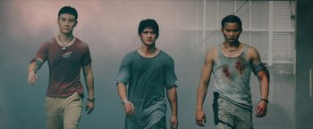 Movie still from “Triple Threat” (2019), directed by Jesse V. Johnson – A group of young men walking down a street; Medium shot, Low angle