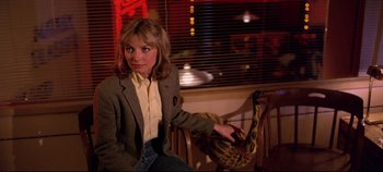 Movie still from “Tron” (1982), directed by Steven Lisberger – A woman sitting on a chair in a room; Medium shot, Over the shoulder angle