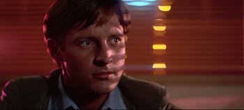 Movie still from “Tron” (1982), directed by Steven Lisberger – A person wearing a suit and tie; Close Up shot, Low angle